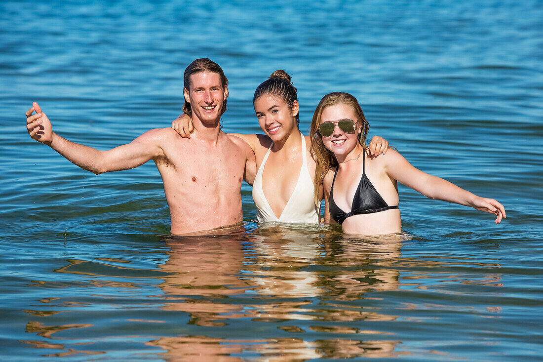 Eine Gruppe von Freunden spielt in den Gewässern des neuseeländischen Abel-Tasman-Nationalparks; Tasman, Neuseeland