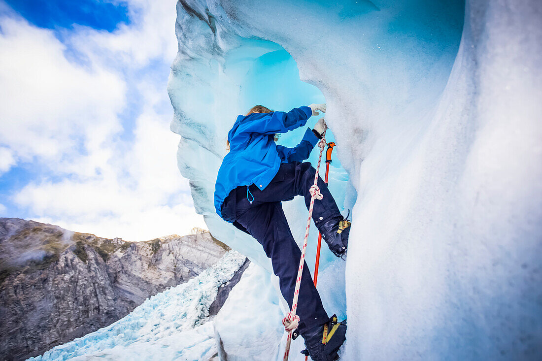 Travellers explore New Zealand's famous Franz Josef Glacier. Blue Ice, deep crevasses, caves and tunnels mark the ever changing ice; West Coast, New Zealand