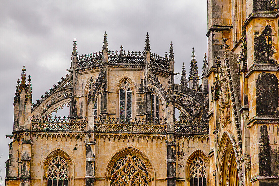 Nahaufnahme des gotischen Mauerwerks und des Daches mit grauem Himmel im Kloster Batalha; Batalha, Bezirk Leiria, Centro Region, Portugal.