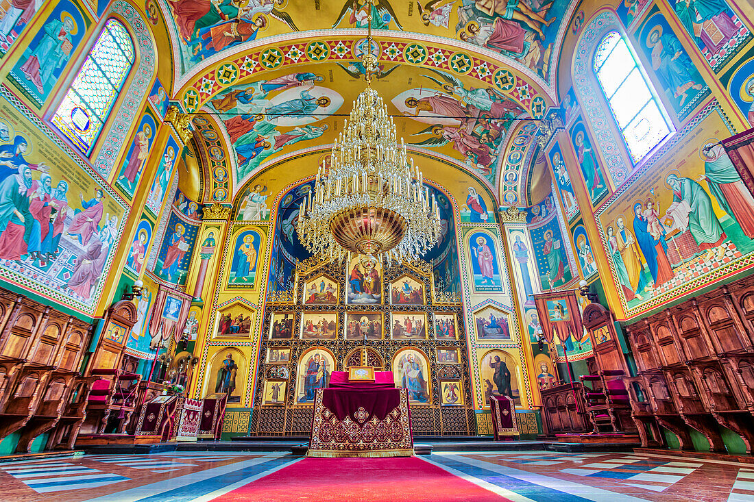 Prächtiger Innenraum der orthodoxen Kathedrale von Zagreb aus dem 19. Jahrhundert mit dem großen Kronleuchter über dem Altar und den farbenfrohen Fresken, die von russischen Künstlern Anfang des 21. Jahrhunderts geschaffen wurden; Zagreb, Kroatien