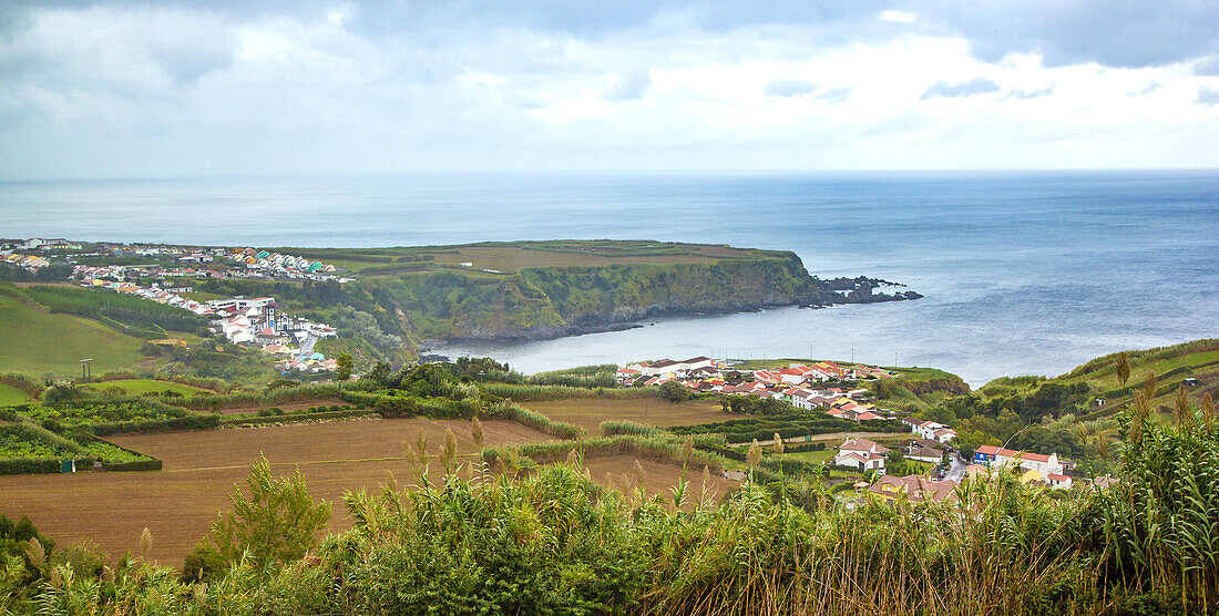 Scenic coastal view of farmland and typical whitewashed buildings overlooking the Atlantic Ocean; Azores