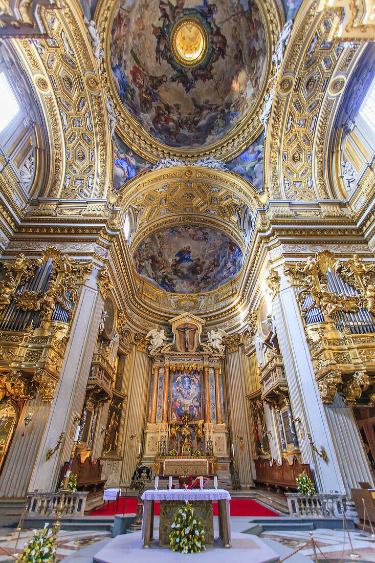 Magnificent interior of Sant'Agnese In Agone Catholic church showing the main altar surrounded by gilded arched windows and ornate domed ceiling above; Rome Lazio, Italy