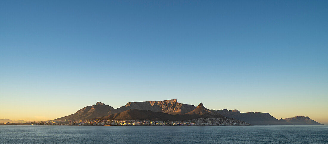 Stunning view of Devil's Peak,Table Mountain and Lion's Head overlooking the port city of Cape Town at dawn from the sea; Cape Town, Cape Province, South Africa