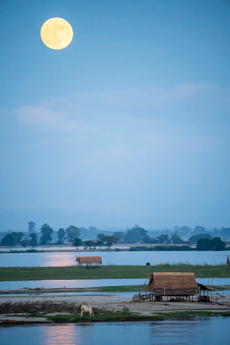 Vollmond über dem Ayeyarwady (Irrawaddy) Fluss mit Fischerhütten in den Feuchtgebieten; Ländlicher Dschungel, Kachin, Myanmar (Burma)