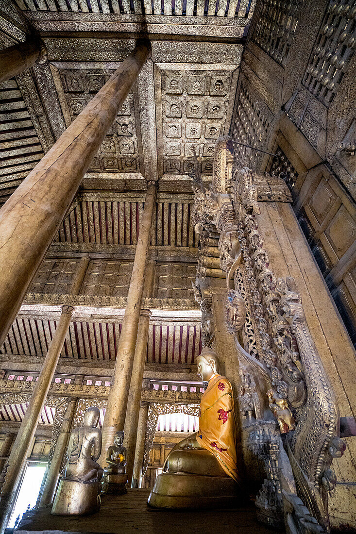 Shwe Nandaw Kyaung Kloster mit vergoldetem Buddha, umgeben von einem mit Holzschnitzereien verzierten Innenraum, Überbleibsel des ursprünglichen Königspalastes von König Mindon; Mandalay, Region Mandalay, Myanmar (Birma).