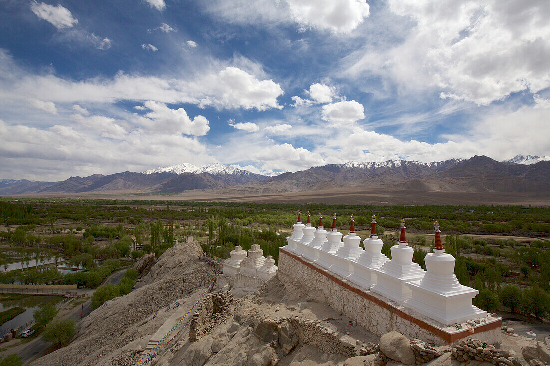 Weiß getünchte buddhistische Stupas (in der tibetischen Kultur als Chortens bekannt) in einer Reihe auf einem Berggipfel bei den Ruinen des Klosters Shey oberhalb des Industals, im Himalaya-Gebirge von Ladakh, Jammu und Kaschmir; Shey, Ladakh, Indien