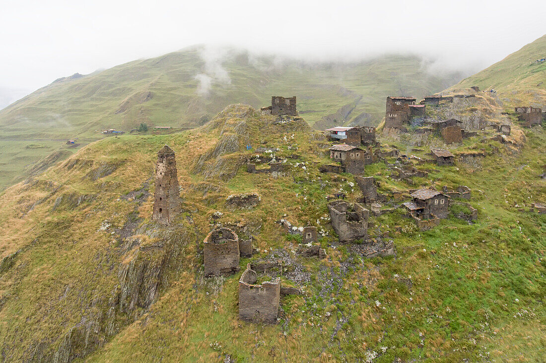 The mountainside village of Kvavlo with its stone houses and ruins of medieval watch towers overlooking the village of Darlto in Tusheti National Park; Kvavlo, Kakheti, Georgia