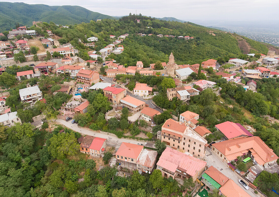 Aerial view of the historic mountainside town of Signagi with its red, clay rooftops overlooking the Greater Caucasus Mountains in Eastern Georgia; Signagi, Kakheti, Georgia