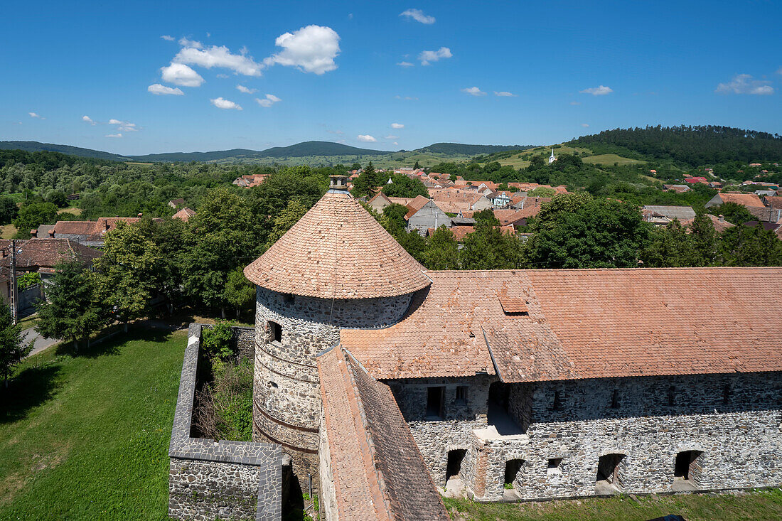 Blick auf die Stadt und den runden Turm der mittelalterlichen Burg Cetatea Bethlen in Racos; Racos, Transsilvanien, Rumänien.