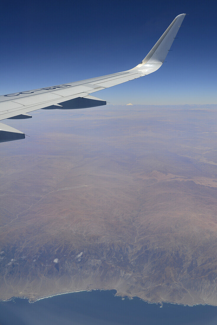 Close-up of the wing of an airplane, flying over the empty dessert of Northern Chile from Andes to sea, 130 miles where nobody lives; Northern Chile, Chile