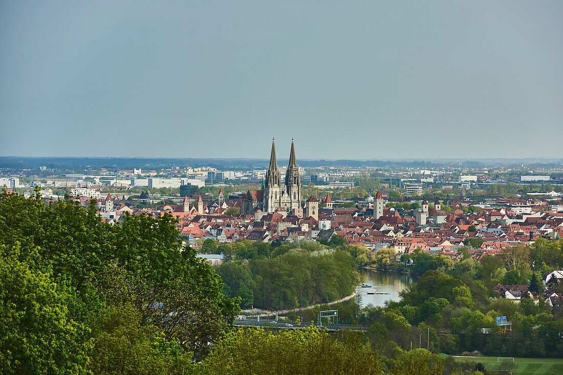 Blick über die Stadt Regensburg vom Dreifaltigkeitsberg mit den Türmen des gotischen Doms St. Peter und der durchfließenden Donau an einem sonnigen Tag; Regensburg, Bayern, Deutschland