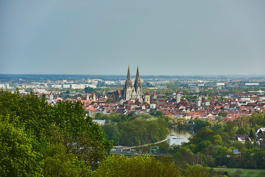 Outlook over the city of Regensburg from Dreifaltigkeitsberg with the spires of the Gothic St Peter's Cathedral and the Danube flowing through on a sunny day; Regensburg, Bavaria, Germany