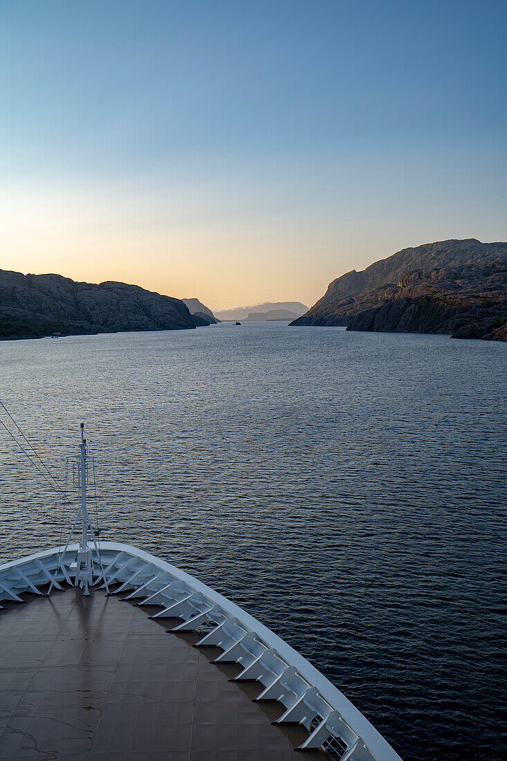 Mitternachtssonne von einem Kreuzfahrtschiff in den Fjorden aus gesehen; Westfjorde, Norwegen