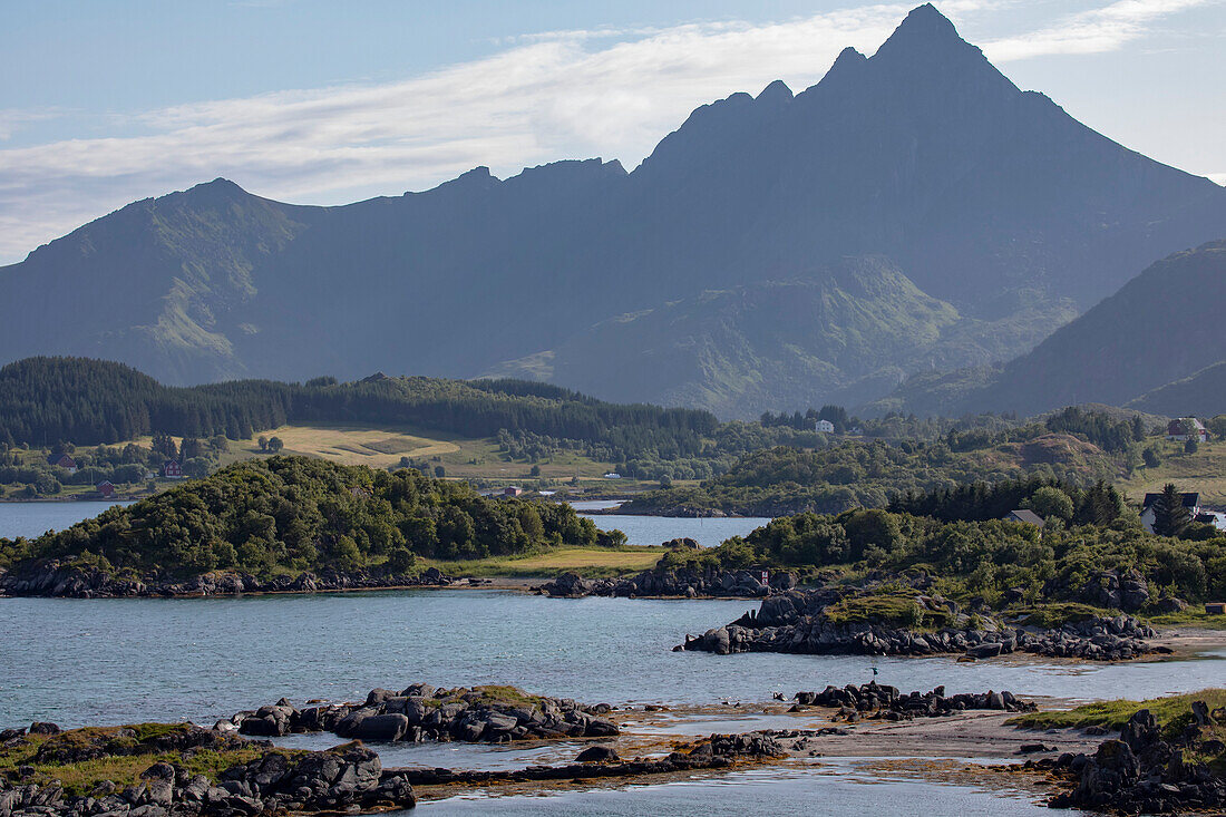 Remote settlement of Gravdal with silhouetted mountain peaks in the distance on on Vestvagoya Island in the Lofoten Islands; Lofoten, Nordland, Norway
