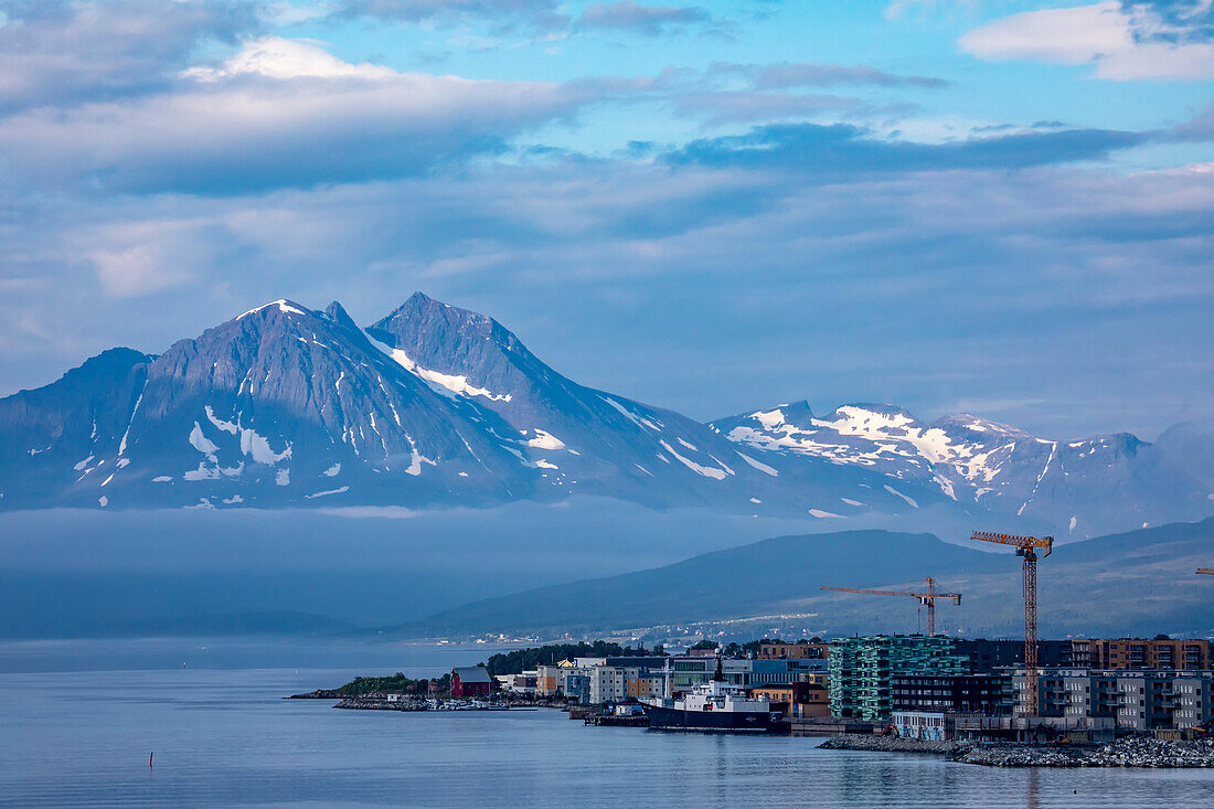 Boote am Hafen von Tromso nördlich des Polarkreises an der Westküste Norwegens, mit dem Nebel und den Bergen im Hintergrund; Tromso, Troms og Finnmark, Norwegen.