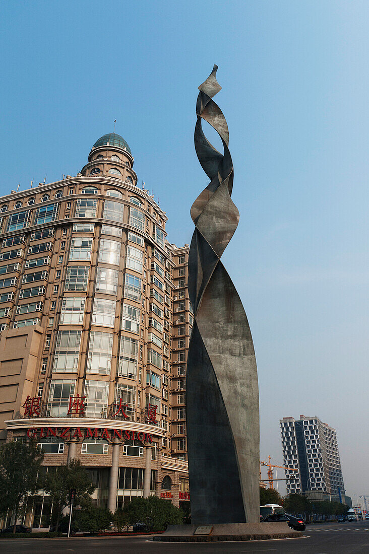 Ein Gebäude und eine Skulptur vor einem blauen Himmel; Tianjin China