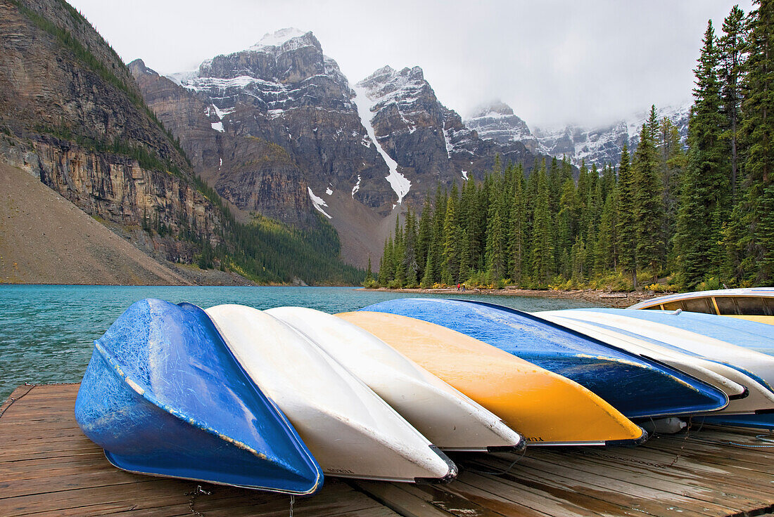 Kanus in einer Reihe auf einem Deck mit den Rocky Mountains im Hintergrund; Alberta Kanada