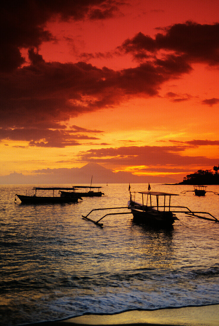 Indonesien, Lombok, Senggigi, Boote auf dem Wasser bei Sonnenuntergang.