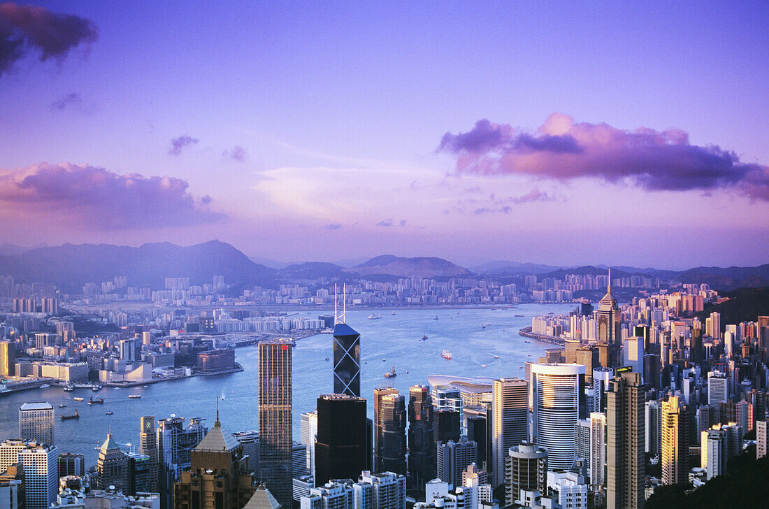 Hongkong, Überblick über Hafen und Skyline in der Dämmerung, rosa und lila Himmel