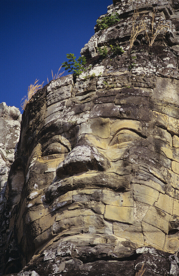 Cambodia, Angkor Thom, Close-up of stone face carving on south temple gate; Bayon