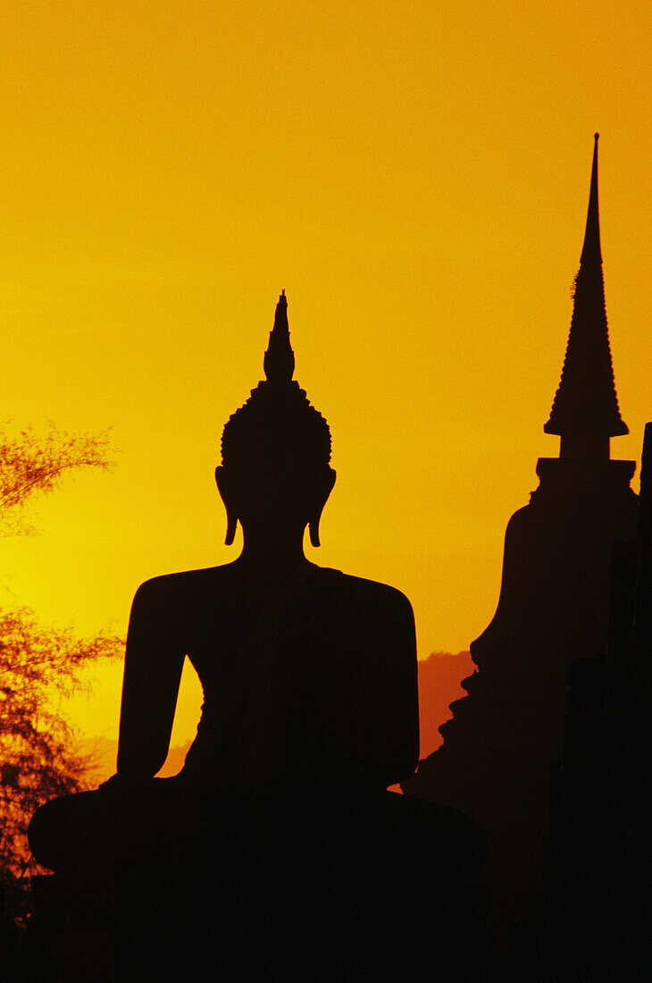 Thailand, Sukhothai, Buddha und Tempel bei Sonnenuntergang, orangefarbener Himmel, Silhouette