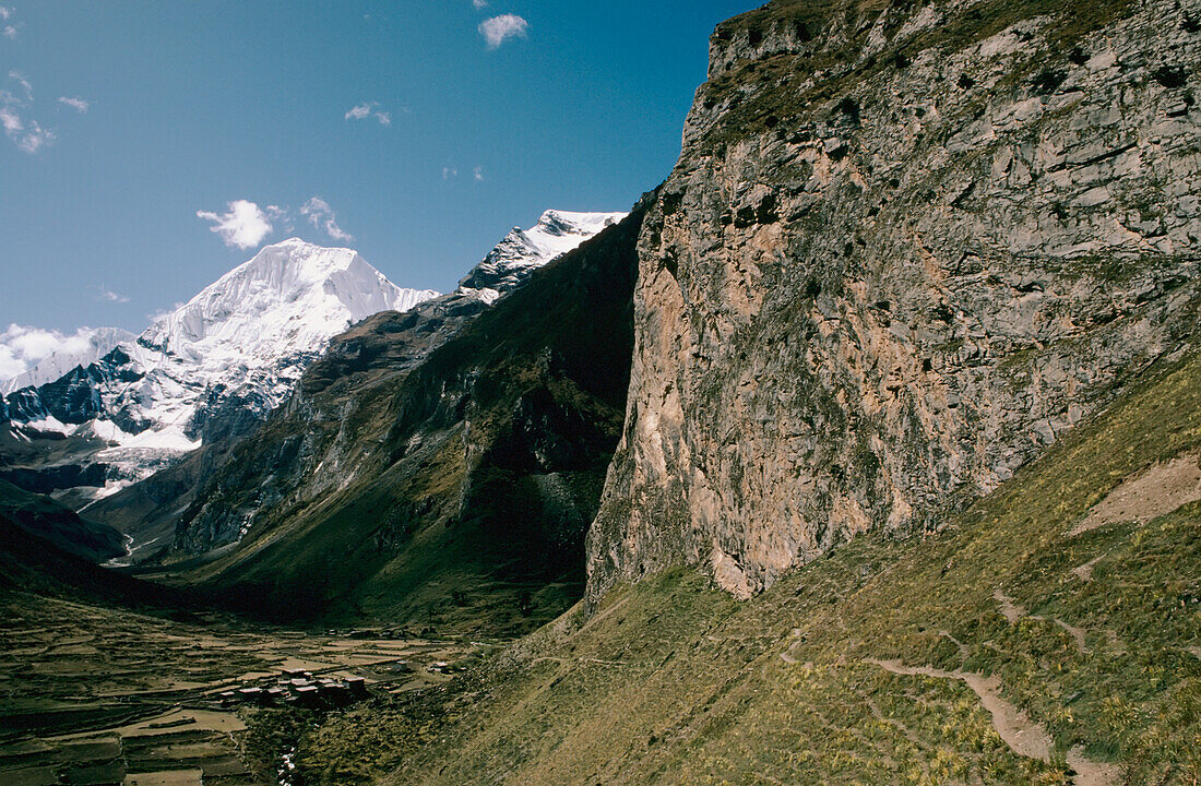 Himalaya; Bhutan, Abgelegenes Ackerland umgeben von Felsen und schneebedeckten Bergen