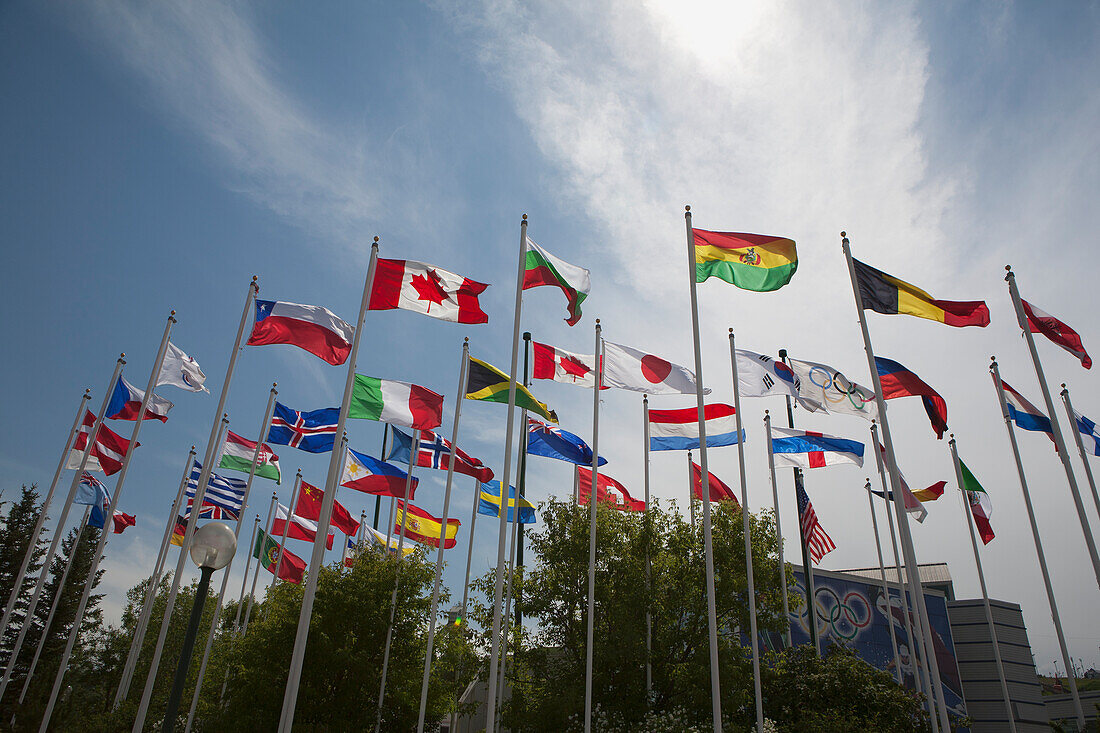 Niedriger Winkel der Weltflaggen mit blauem Himmel und Wolken; Calgary Alberta Kanada