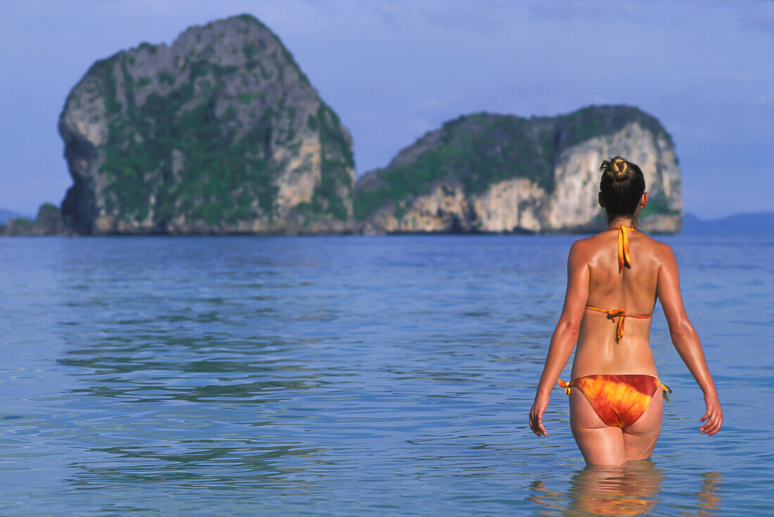 Eine Touristin im Bikini genießt den Sonnenschein auf der tropischen Insel Koh Ngai oder Ko Ngai bei Trang; Koh Ngai Thailand