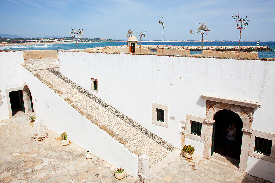 Einzigartige Skulpturen entlang der Dachlinie eines weißen Gebäudes; Lagos Algarve Portugal