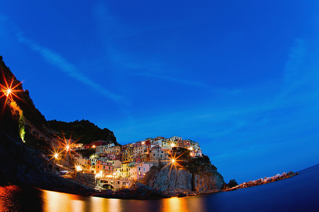 Ein Dorf im Nationalpark Cinque Terre bei Nacht beleuchtet; Manarola Italien