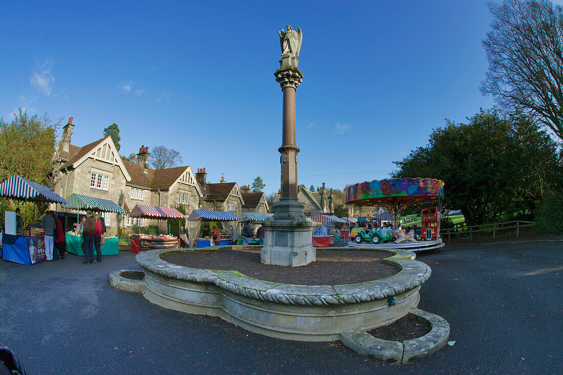 Ein hohes Monument und Einkäufer auf einem Markt; Ford Northumberland England