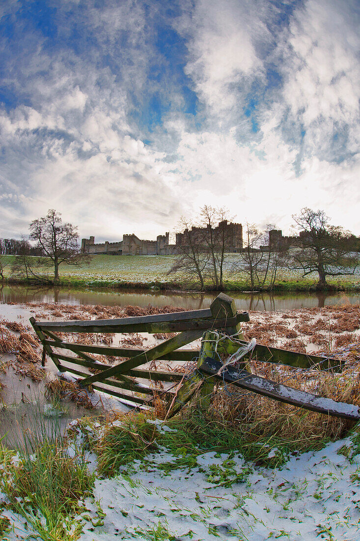 Spuren von Schnee entlang des Flusses mit Alnwick Castle in der Ferne; Alnwick Northumberland England