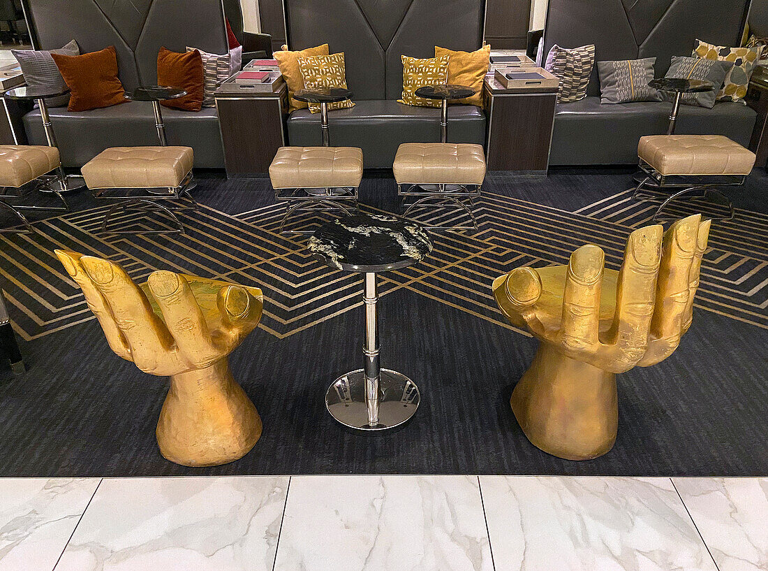 Gold Hand-Shaped Chairs and other Modern Furniture in Hotel Lobby