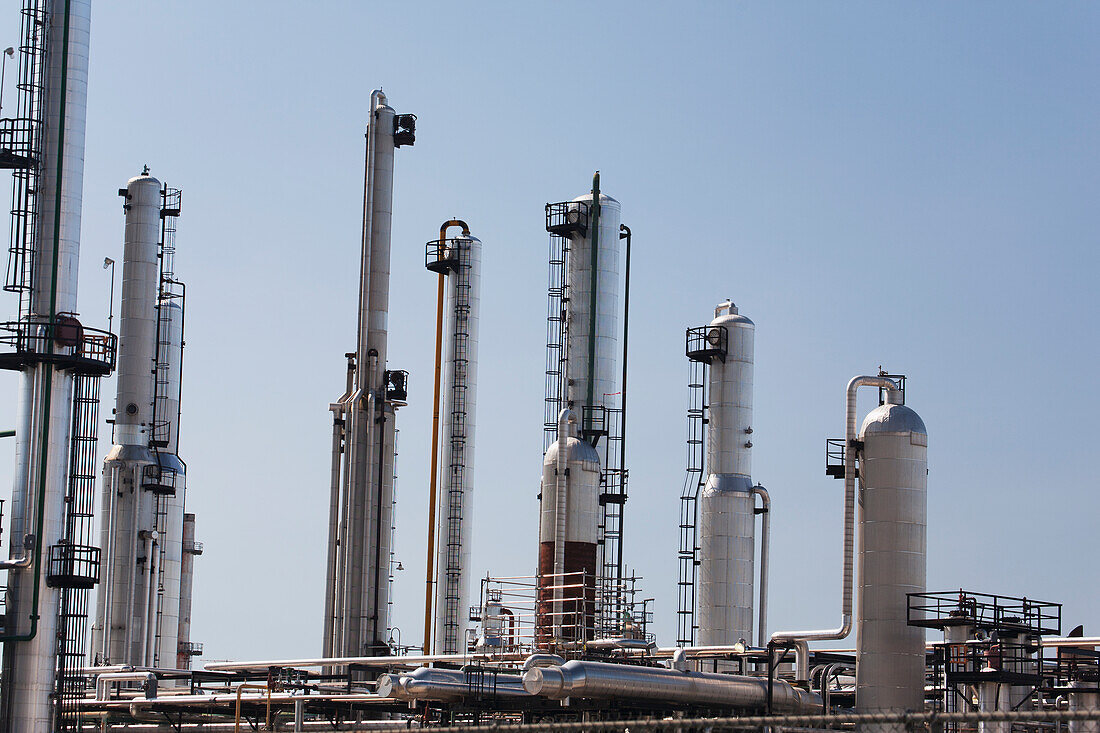 Towers Of A Refinery Against A Blue Sky; Alberta Canada