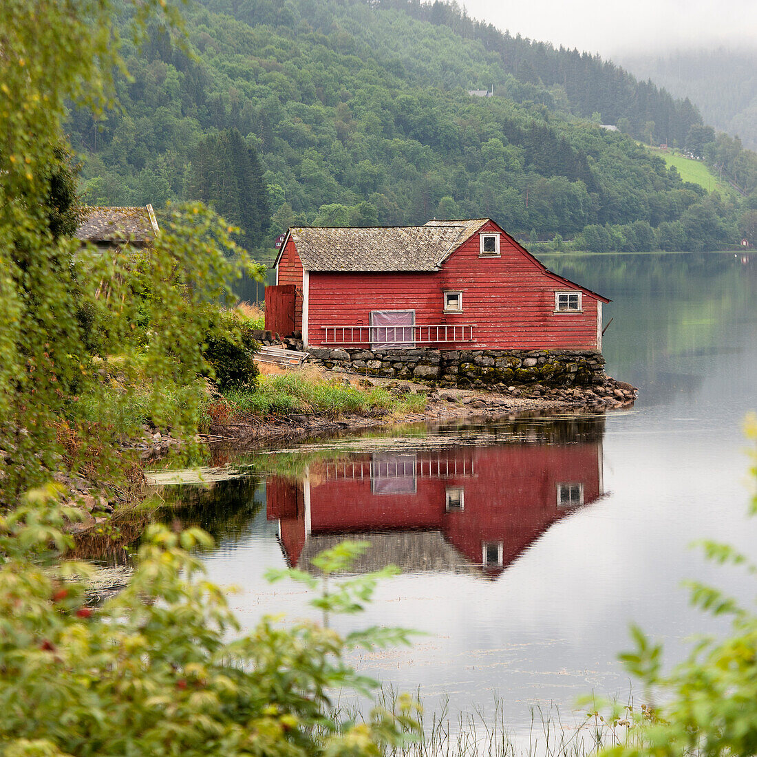 Ein rotes Haus am Rande des Wassers; Granvin Hordaland Norwegen