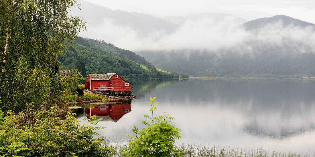 A Red House Along Granvinsvatnet With Low Lying Cloud; Granvin Hordaland Norway