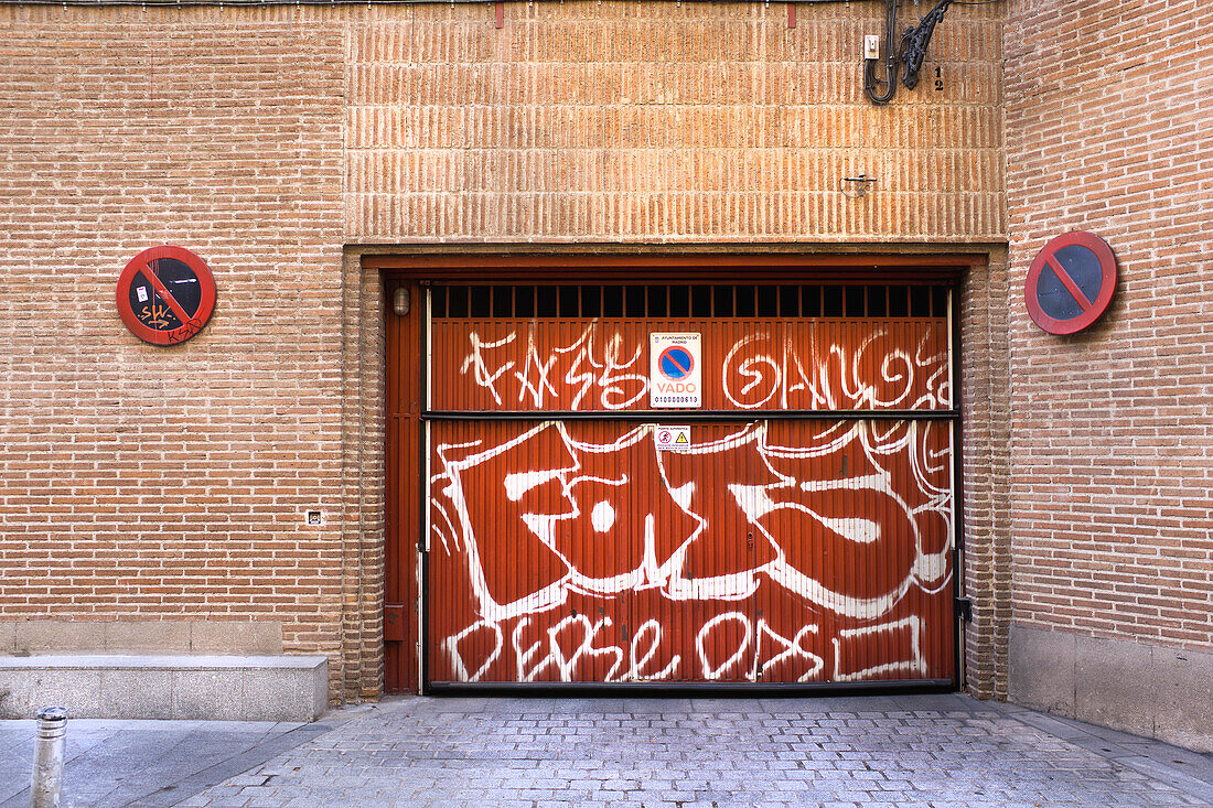 No parking sign at loading dock painted with graffiti, Madrid, Spain