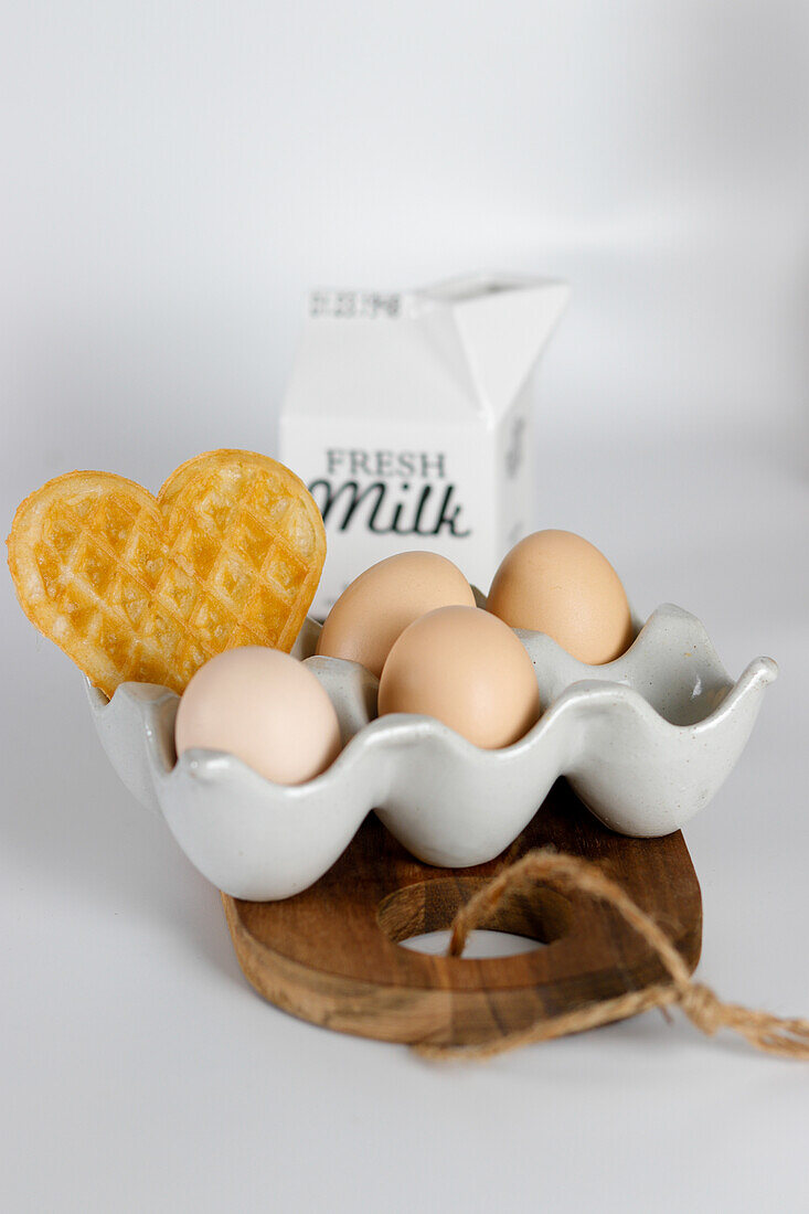 Eggs with waffle heart in ceramic egg holder