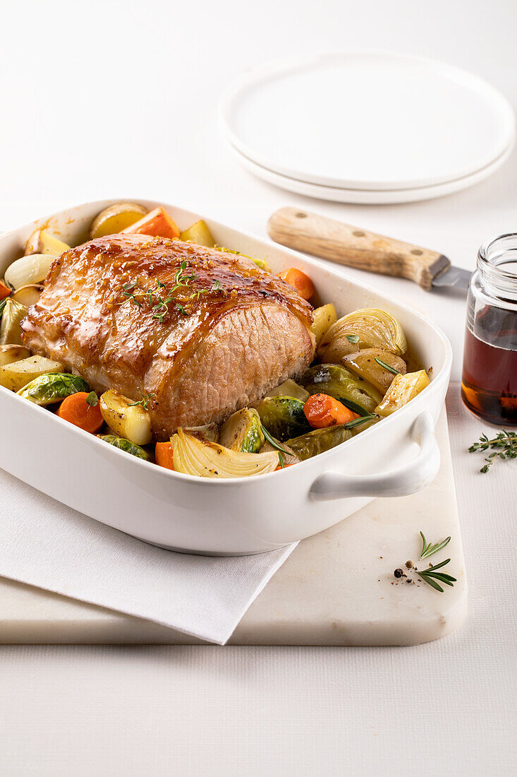 Roast pork with vegetables in baking dish
