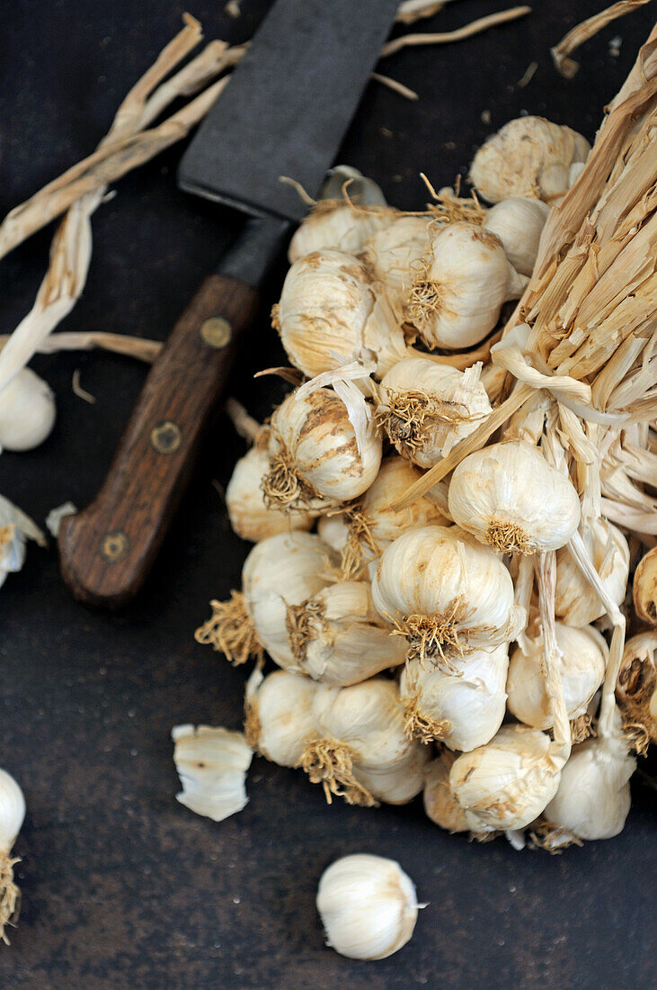 A bunch of fresh garlic with knife