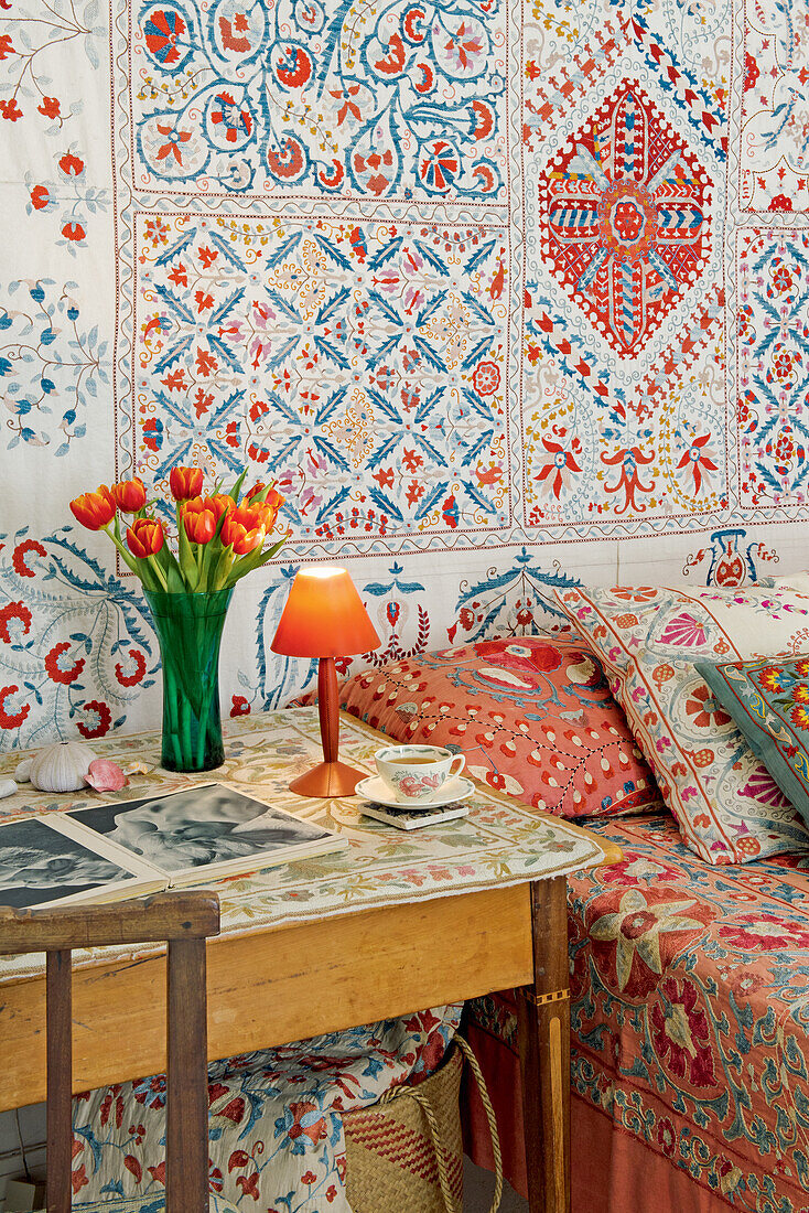 Colourful fabrics in the bedroom with wooden table next to the bed