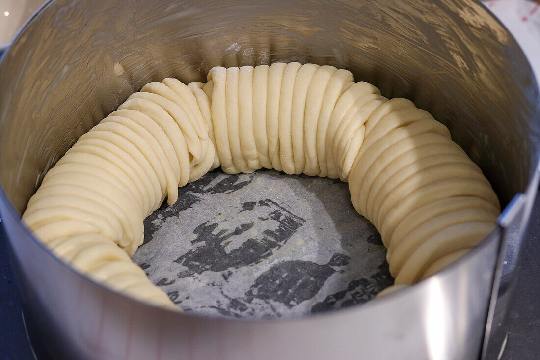 Preparing Easter brioche: rolled yeast dough in springform pan