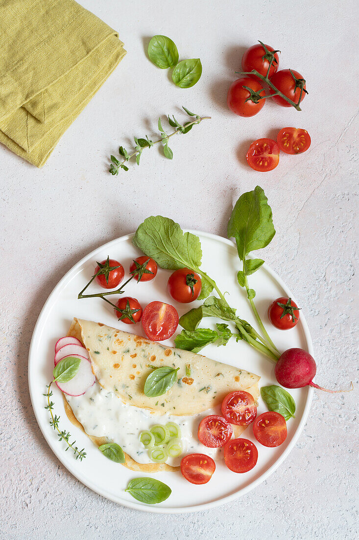 Aromatic herb crepes with Crescenza cheese and cherry tomatoes