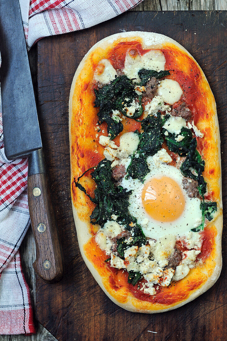 Hausgemachte Pizza mit Spinat, Mozzarella und Ei