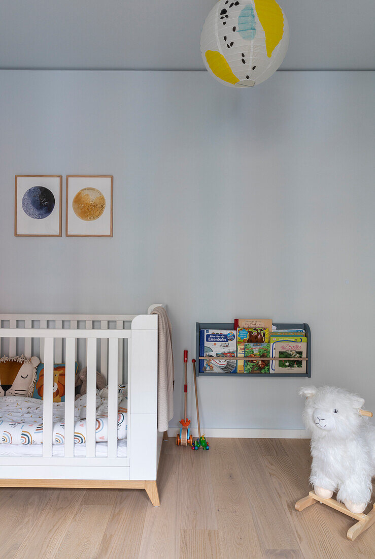 Kinderzimmer mit weißem Gitterbett, Wandregal für Bücher und Spielzeug-Lama