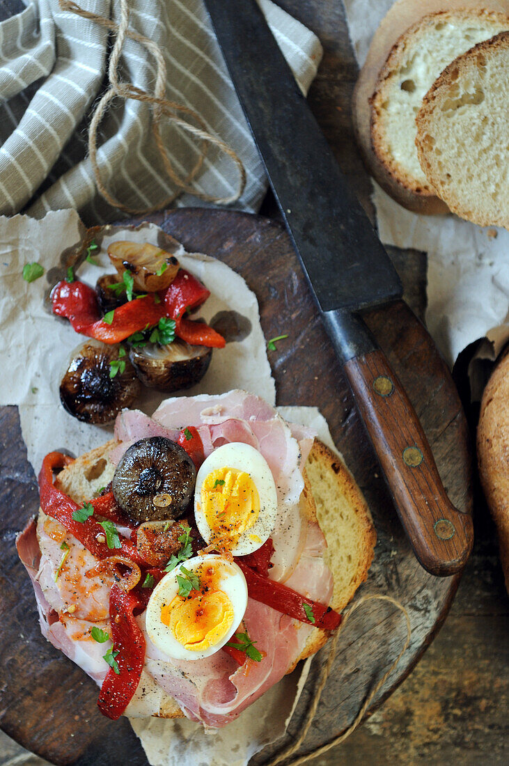 Gekochte Eier, Schinken und Paprika auf italienischem Brot