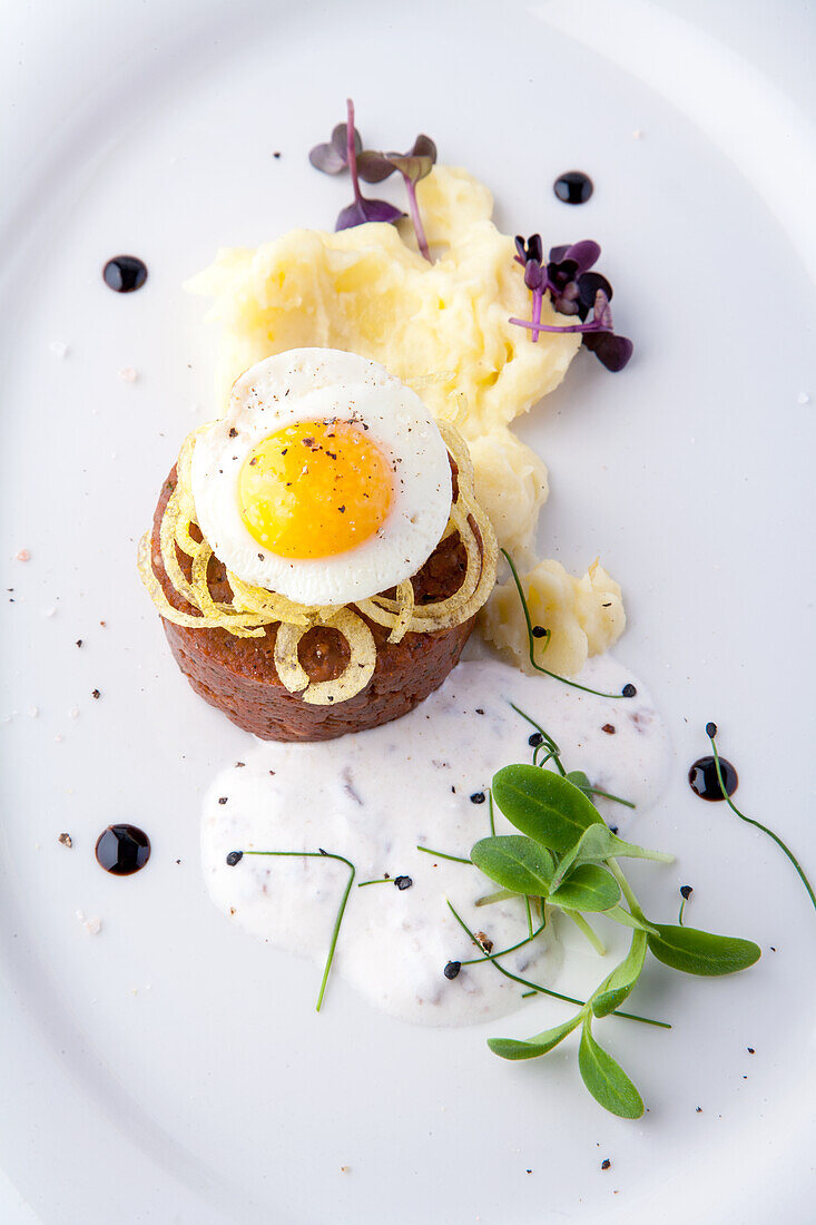 Beef tartare with onions and fried egg and mashed potatoes