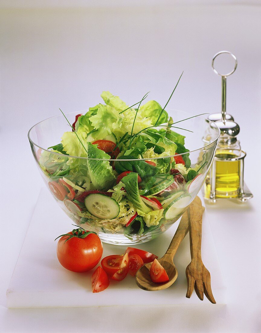 A Large Bowl of Tossed Salad; Salad Servers and Tomatoes