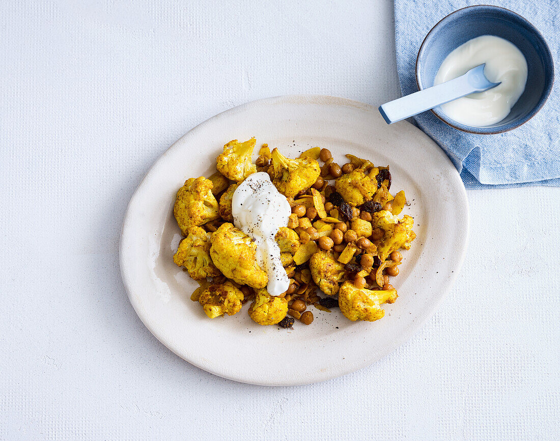 Baked cauliflower with chickpeas, raisins and almond flakes