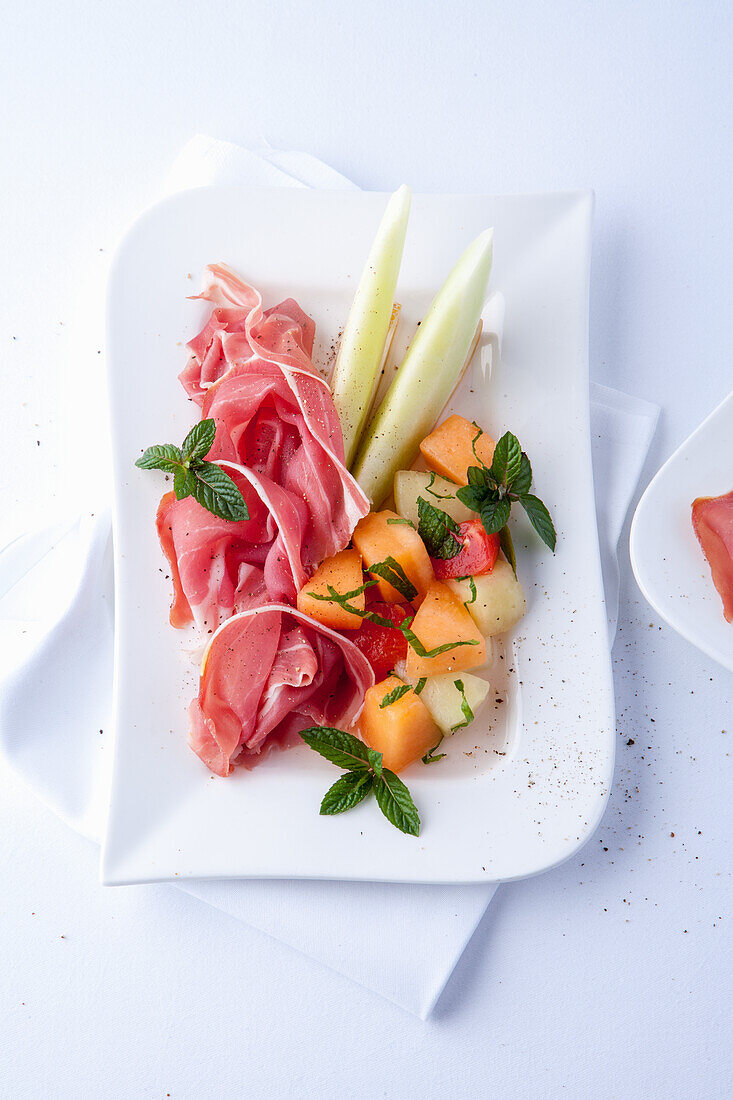 Verschiedene Melonensorten mit Schinken